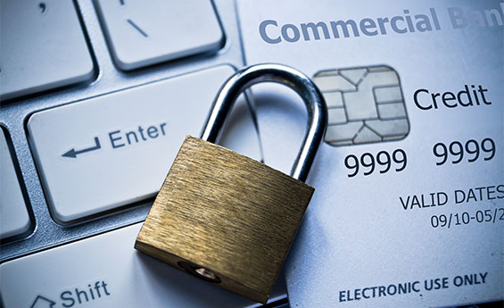 Locked padlock and credit card laying on computer keyboard indicating date breach protection.